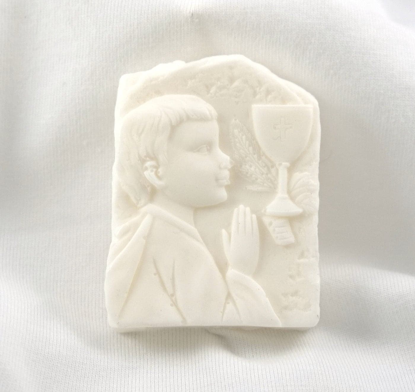 Jabón en relieve de un niño orando
